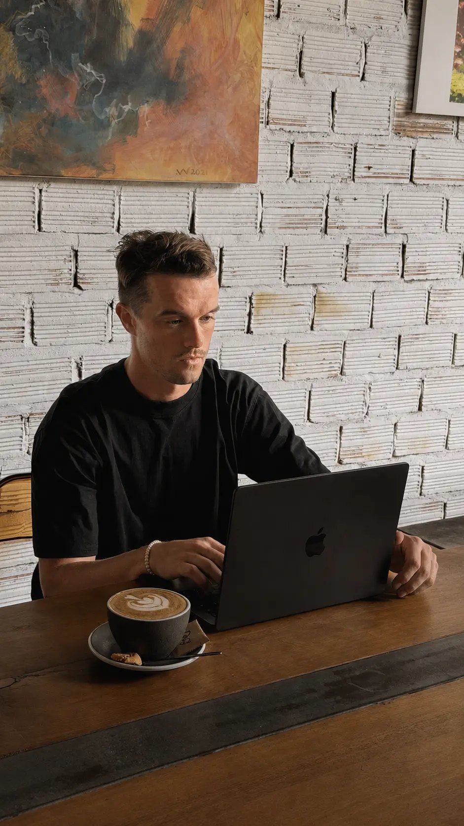 Richard Dineen working on a website at a wooden table